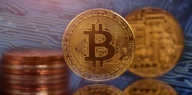 Golden Bitcoin cryptocurrency on circuit board background