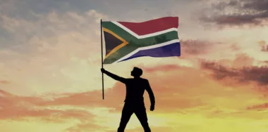 Male silhouette figure waving South Africa flag