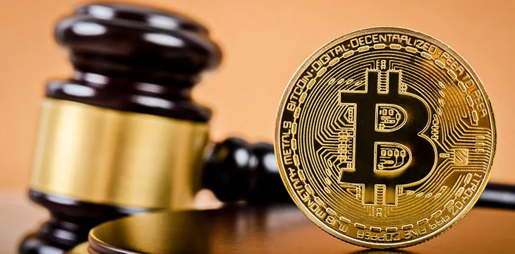 Golden Bitcoin and judge's gavel in the background