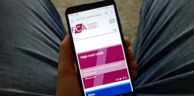 Man holding smartphone with Financial Conduct Authority