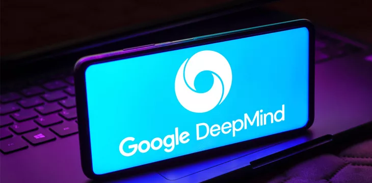 Google DeepMind logo shown on smartphone screen with computer in the background