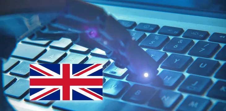 Robotic hand typing on a keyboard with the English flag
