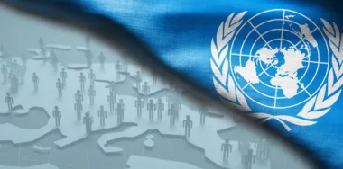 United Nations flag folded with background of economic population concept