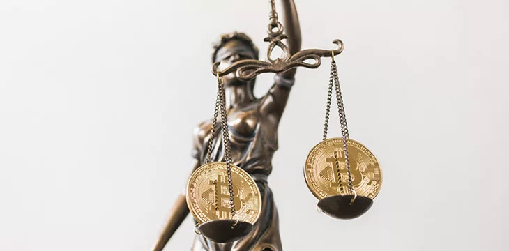 gold bitcoins on the scale of the statue of justice