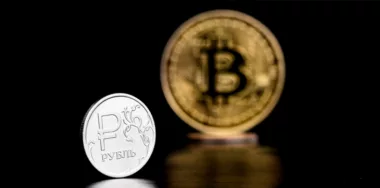 Coin with Russian ruble symbol and coin with bitcoin cryptocurrency symbol