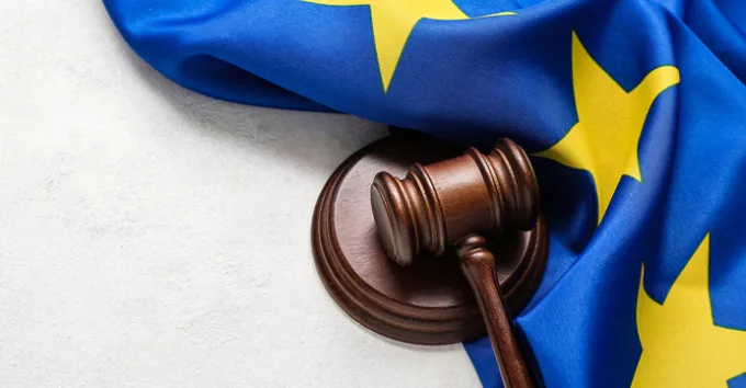 Judge's gavel and flag of European Union on white table