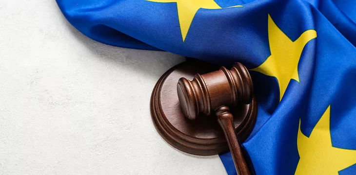 Judge's gavel and flag of European Union on white table