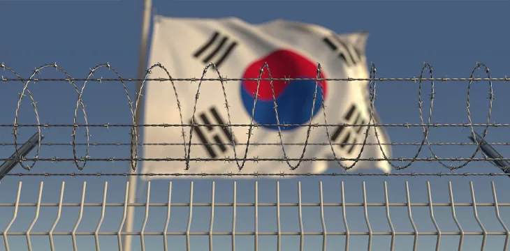 Barbed wire against waving flag of South Korea