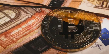 Bitcoin coin on banknotes background close-up