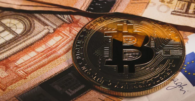 Bitcoin coin on banknotes background close-up