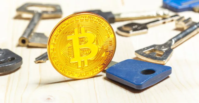 Bitcoin coins and keys on wooden table