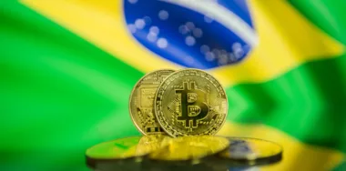 Bitcoin gold coin and defocused flag of Brazil