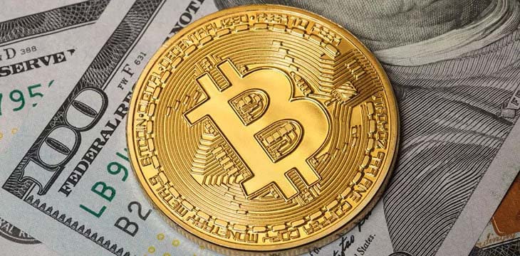 Bitcoin coins and hundred dollar bills