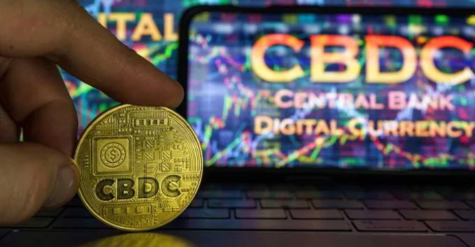 Central Bank Digital Currency logo on a coin and laptop