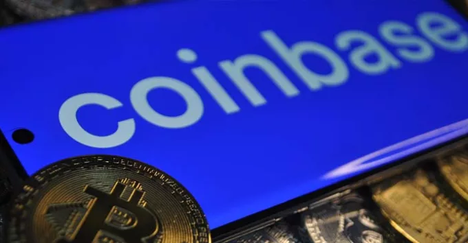 Coinbase logo on a mobile phone with BTC coins