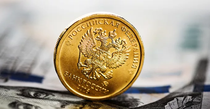 Russian ruble coin on banknotes of U.S. dollars