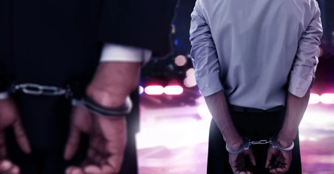 Two businessman in handcuffs