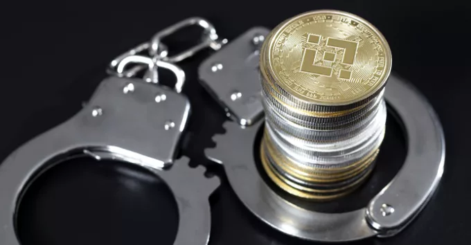 Stack of binance coins and handcuffs over black background
