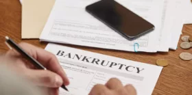 Partial view of businessman filling in bankruptcy form