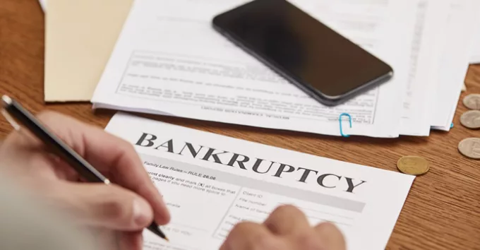 Partial view of businessman filling in bankruptcy form