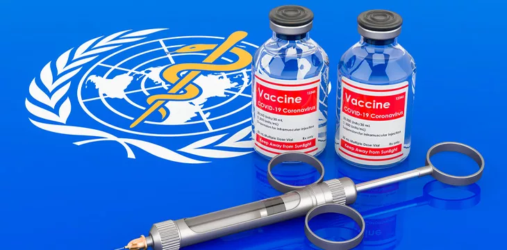 Vaccine bottles with syringe on the World Health Organization flag