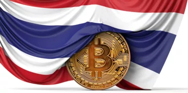Thailand flag draped over a digital currency coin