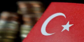 Turkey flag waving with stack of money coins in the background