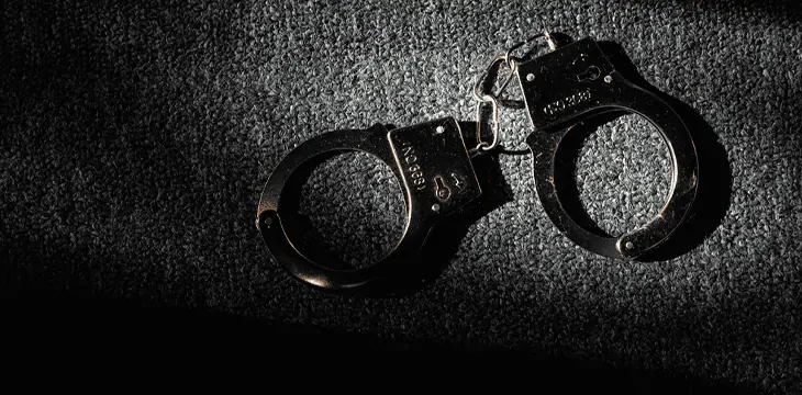 black handcuffs on wooden background