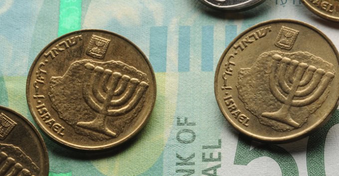 Close up of Israeli coins on banknote