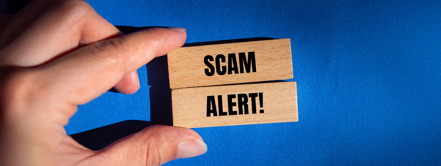 Scam alert message on wooden block