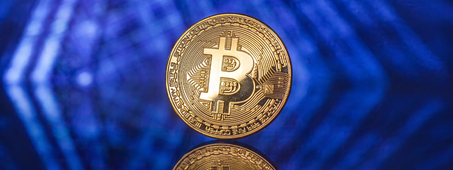 Golden Bitcoin on blue background