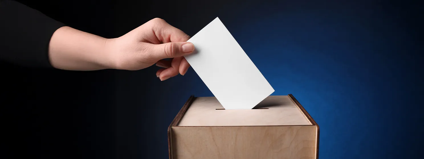 Hand putting vote into ballot box