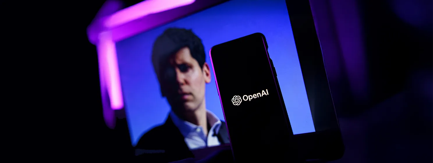 OpenAI logo on a phone screen with Sam Altman in the background