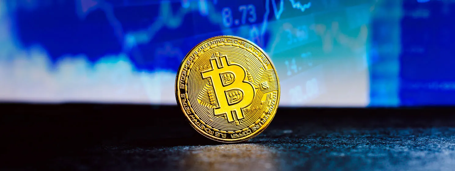 gold BTC coin over financial report