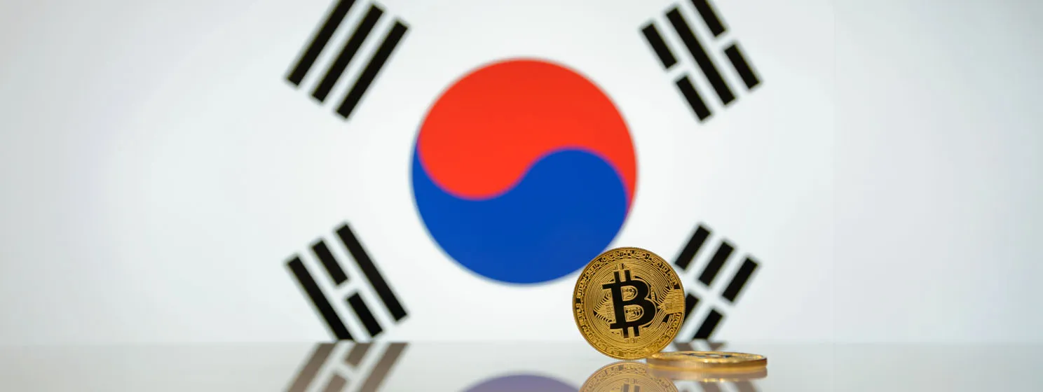 Golden bitcoin stands on a blurred background of South Korea flag