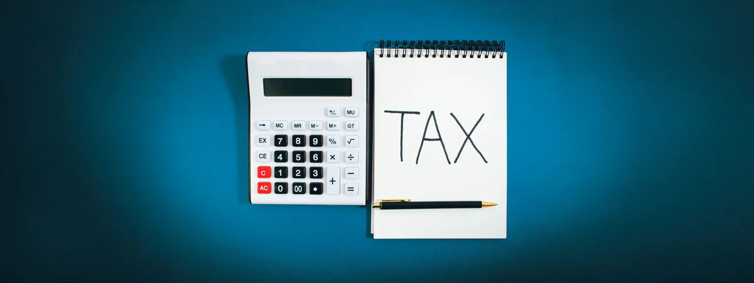 Calculator and written tax on a blue background