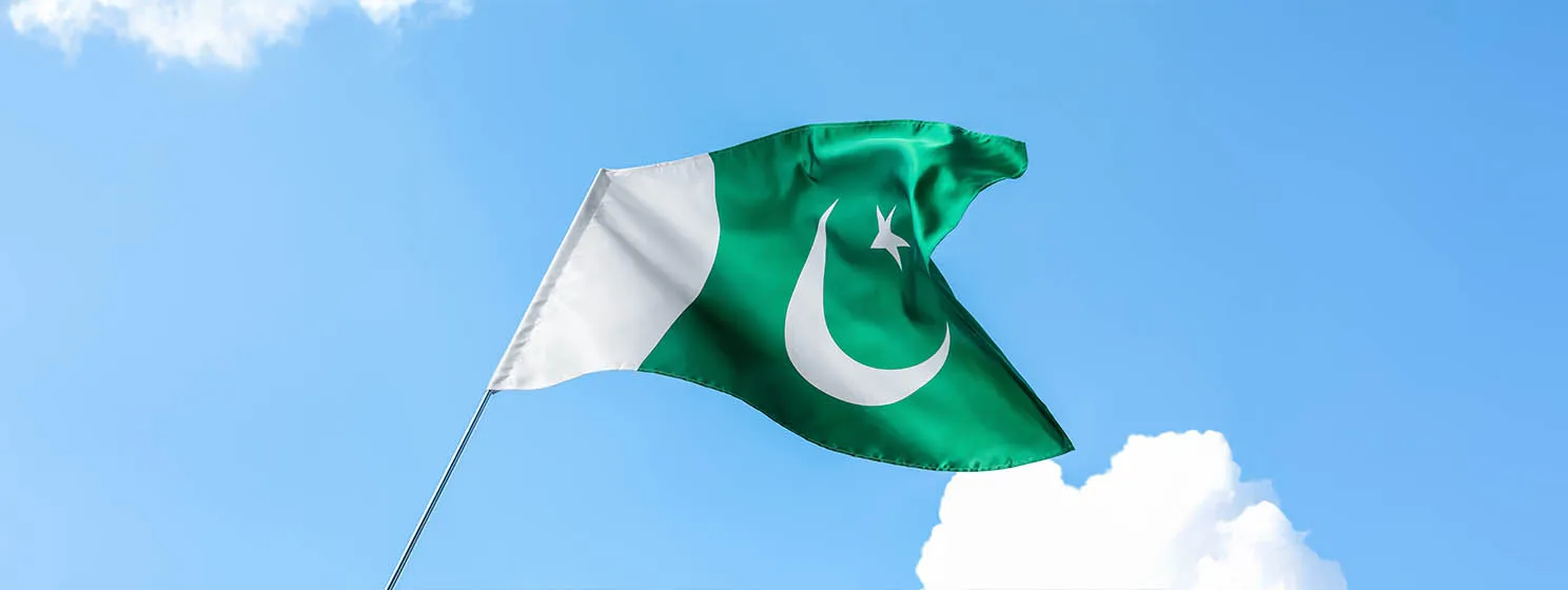 Pakistan flag outdoors against blue sky.