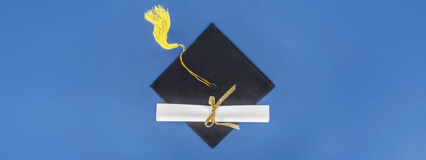 Graduation concept with diploma and graduation cap isolated on blue background.