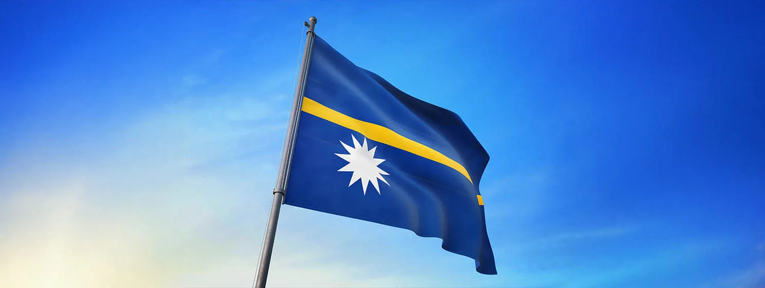 Nauru flag waving on the blue sky on the wind.