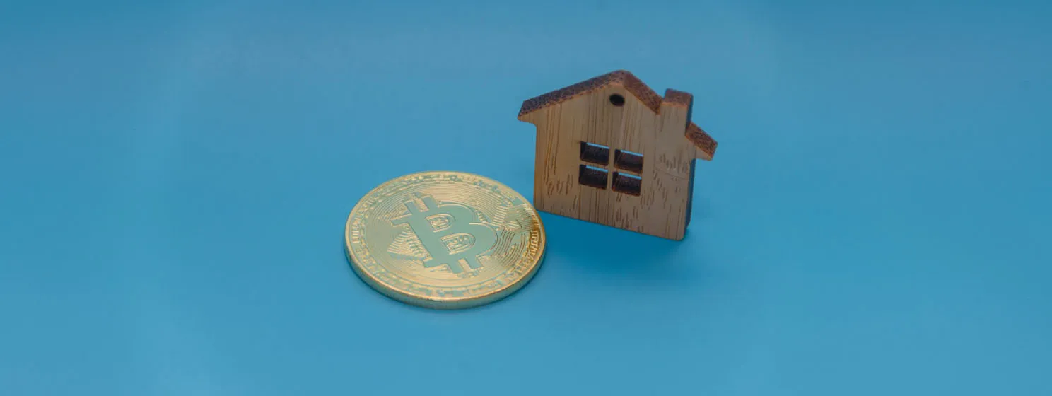 Wooden house, toy and Golden bitcoin on blue background