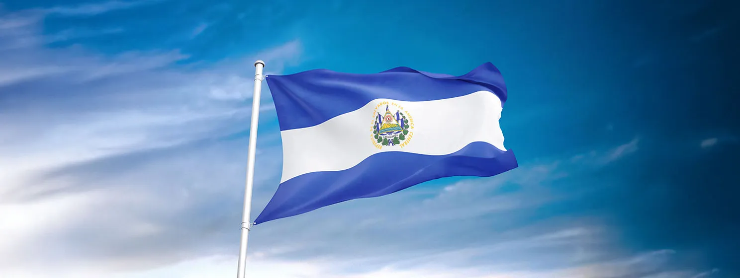 El Salvador flag waving in the cloudy sky.