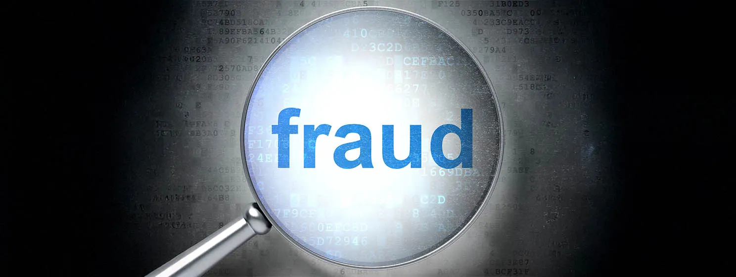 Fraud text with magnifying glass.