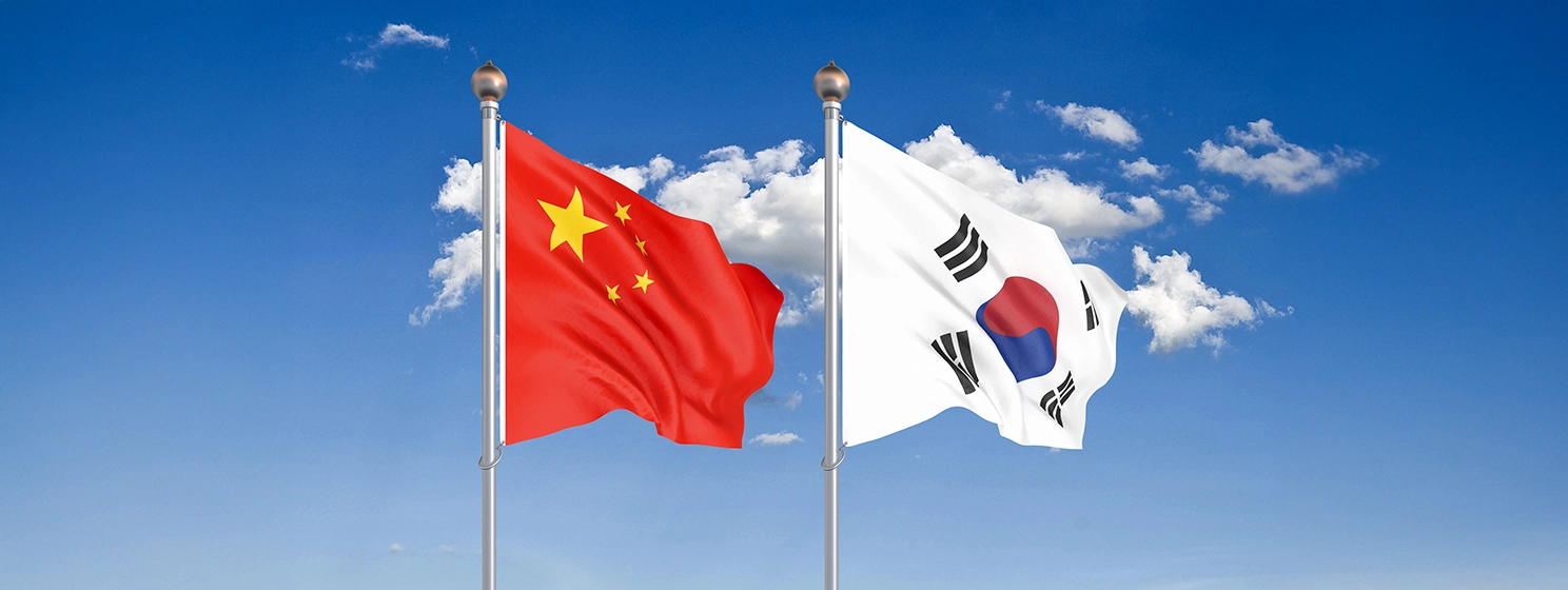 China vs South Korea. Thick colored silky flags waving in the air.