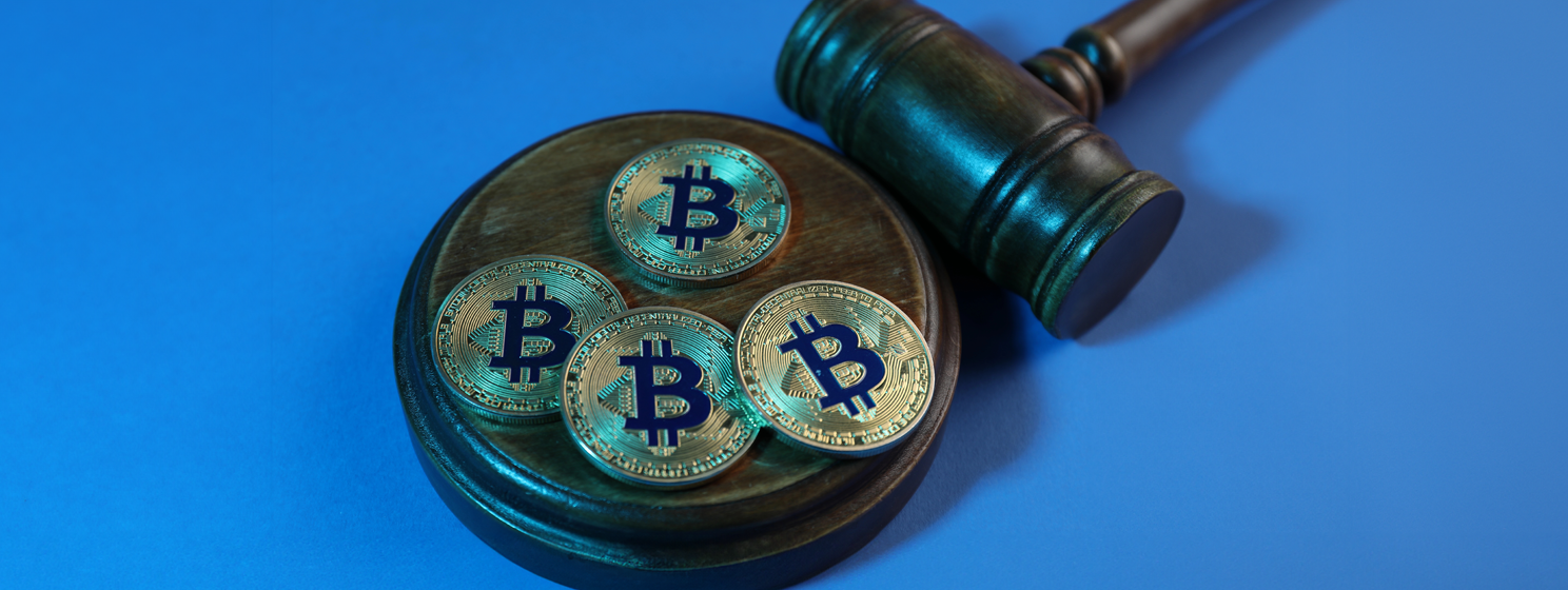 Bitcoins and judge's gavel on light blue background