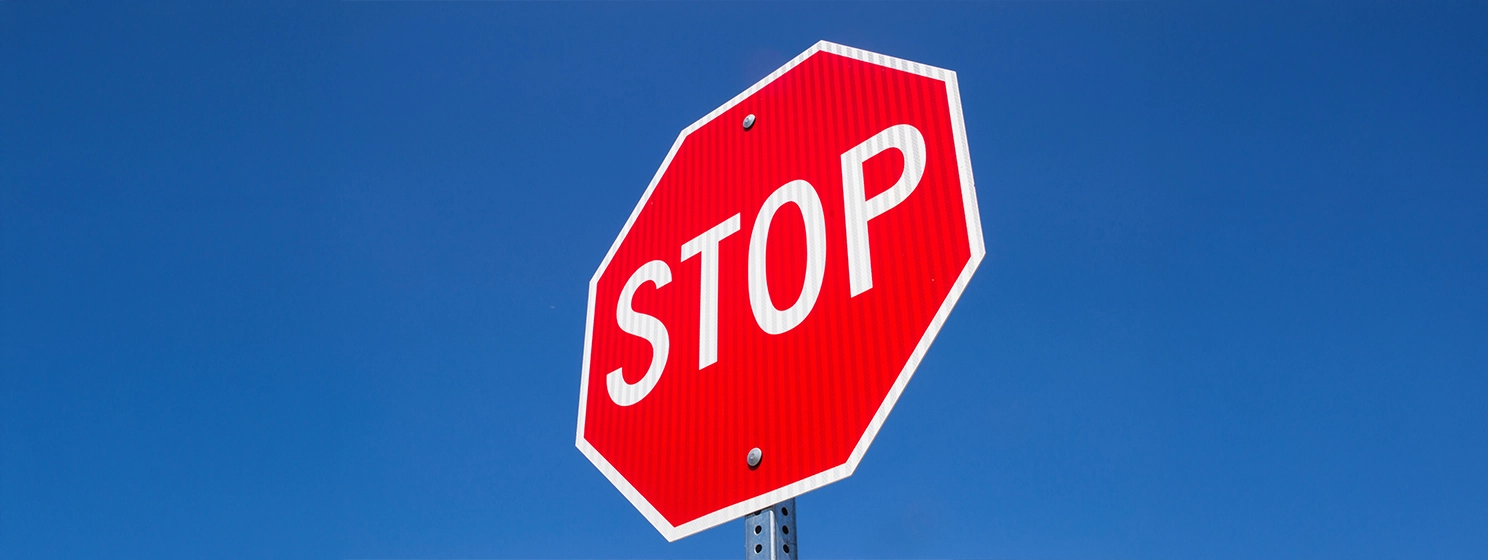 The stop sign with blue sky background.