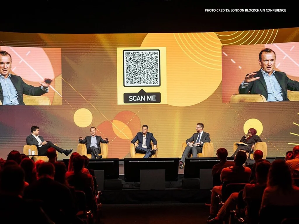 Panelist speaking at the London Blockchain Conference stage.
