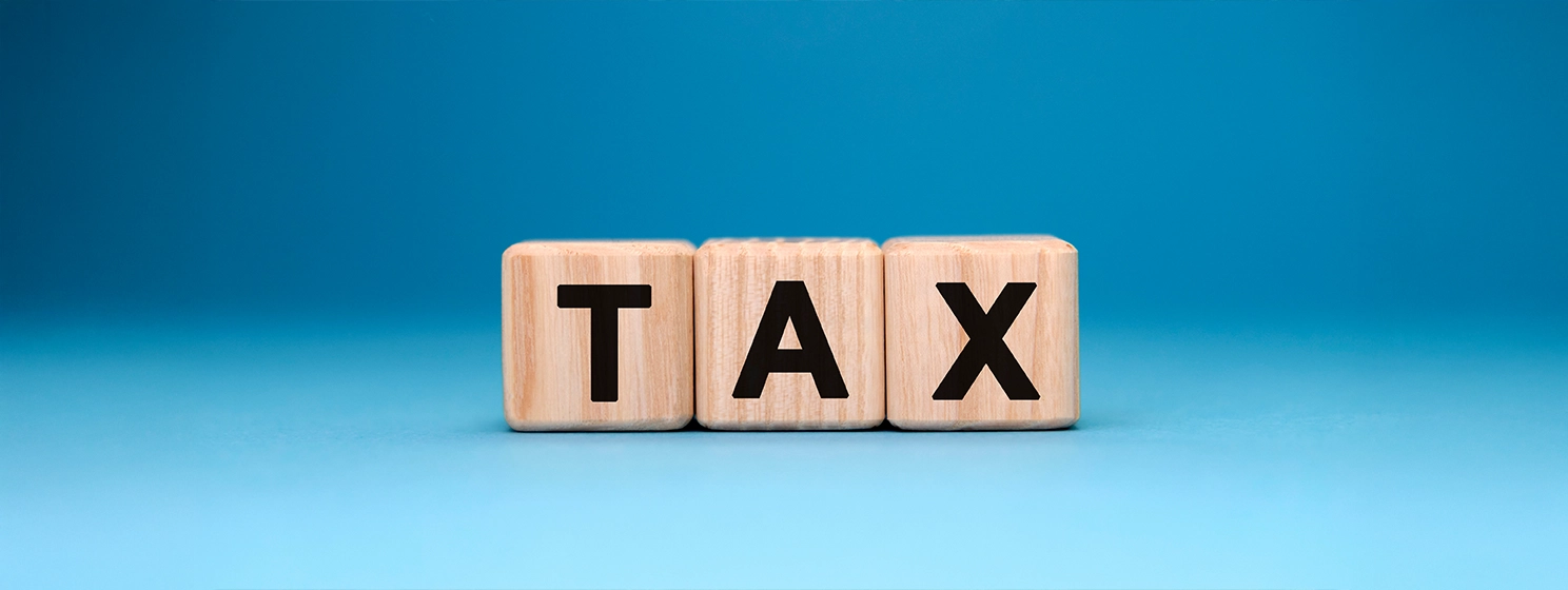 TAX word cube on a blue background.